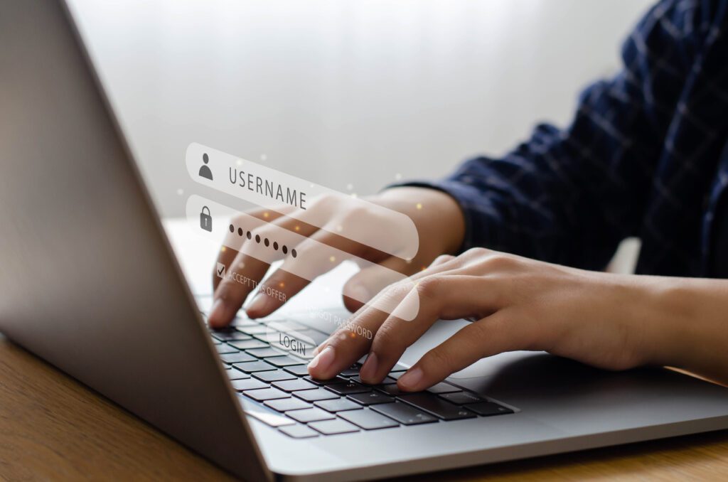 Pessoa digitando em um notebook com uma interface de login projetada na tela, mostrando campos de "username" e "password", destacando conceitos de segurança cibernética e privacidade online, voltados para a proteção de dados pessoais.

